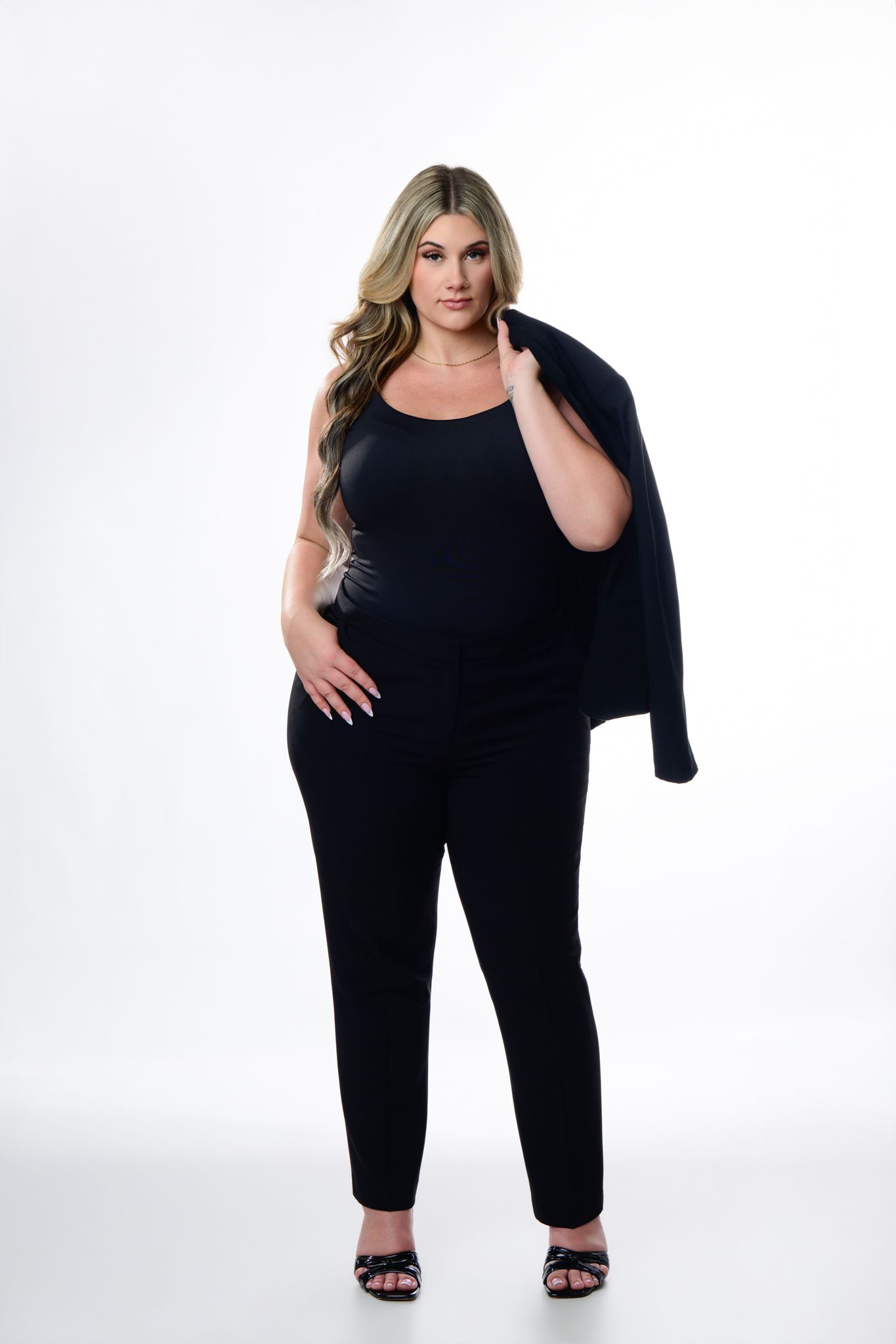 Studio portrait of a person standing in black against a bright background