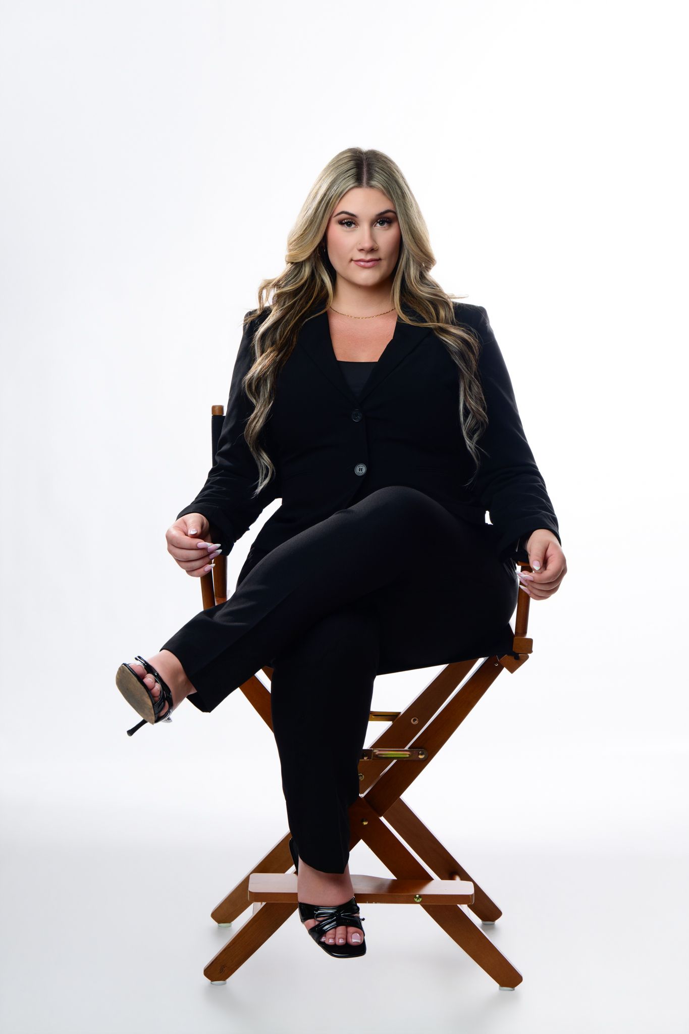 Studio portrait of a person seated in black against a bright background