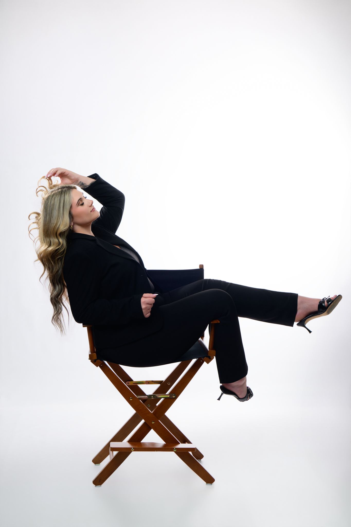 Angelina seated in a studio chair against a bright background
